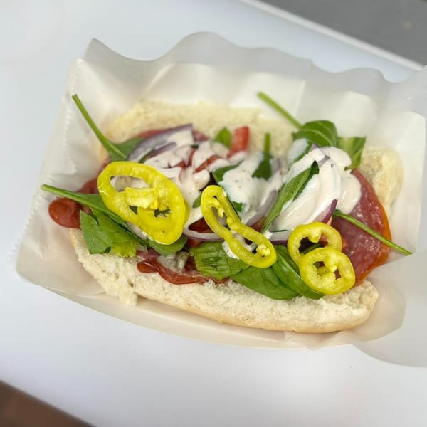 A Clover Leaf on Franklin sub sandwich with pepperoni, spinach, onions, peppers, and white sauce.