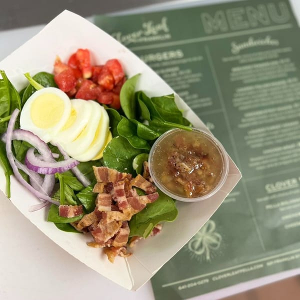 A Clover Leaf on Franklin salad with spinach, bacon, hard-boiled egg, red onion, and tomatoes.